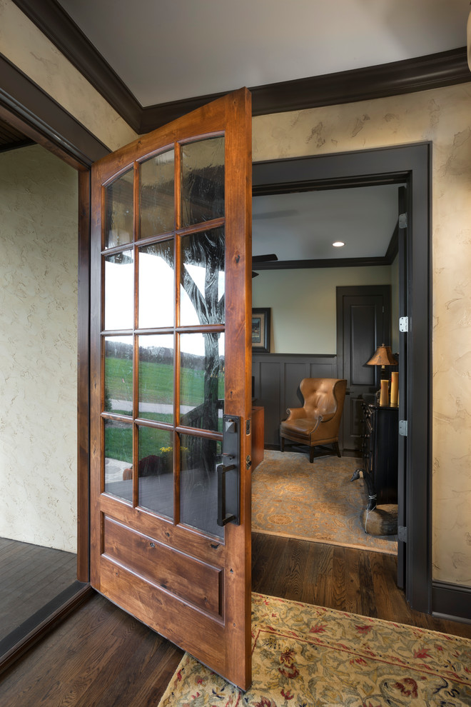 Ispirazione per una piccola porta d'ingresso stile rurale con pareti gialle, pavimento in legno massello medio, una porta singola e una porta in legno bruno