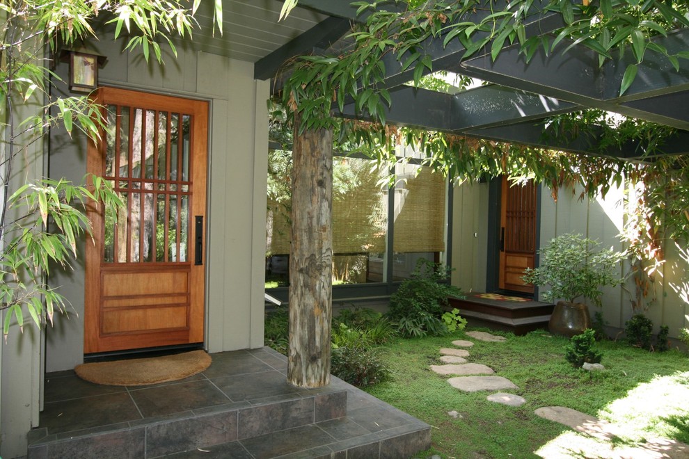 Пример оригинального дизайна: прихожая в восточном стиле с одностворчатой входной дверью и входной дверью из дерева среднего тона