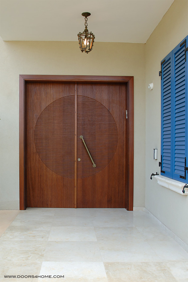 This is an example of a world-inspired front door in Austin with a double front door and a medium wood front door.