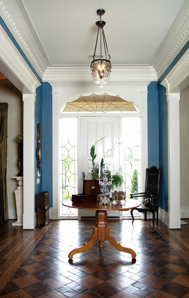 Imagen de distribuidor tradicional grande con paredes azules, suelo de madera en tonos medios, puerta simple y puerta blanca