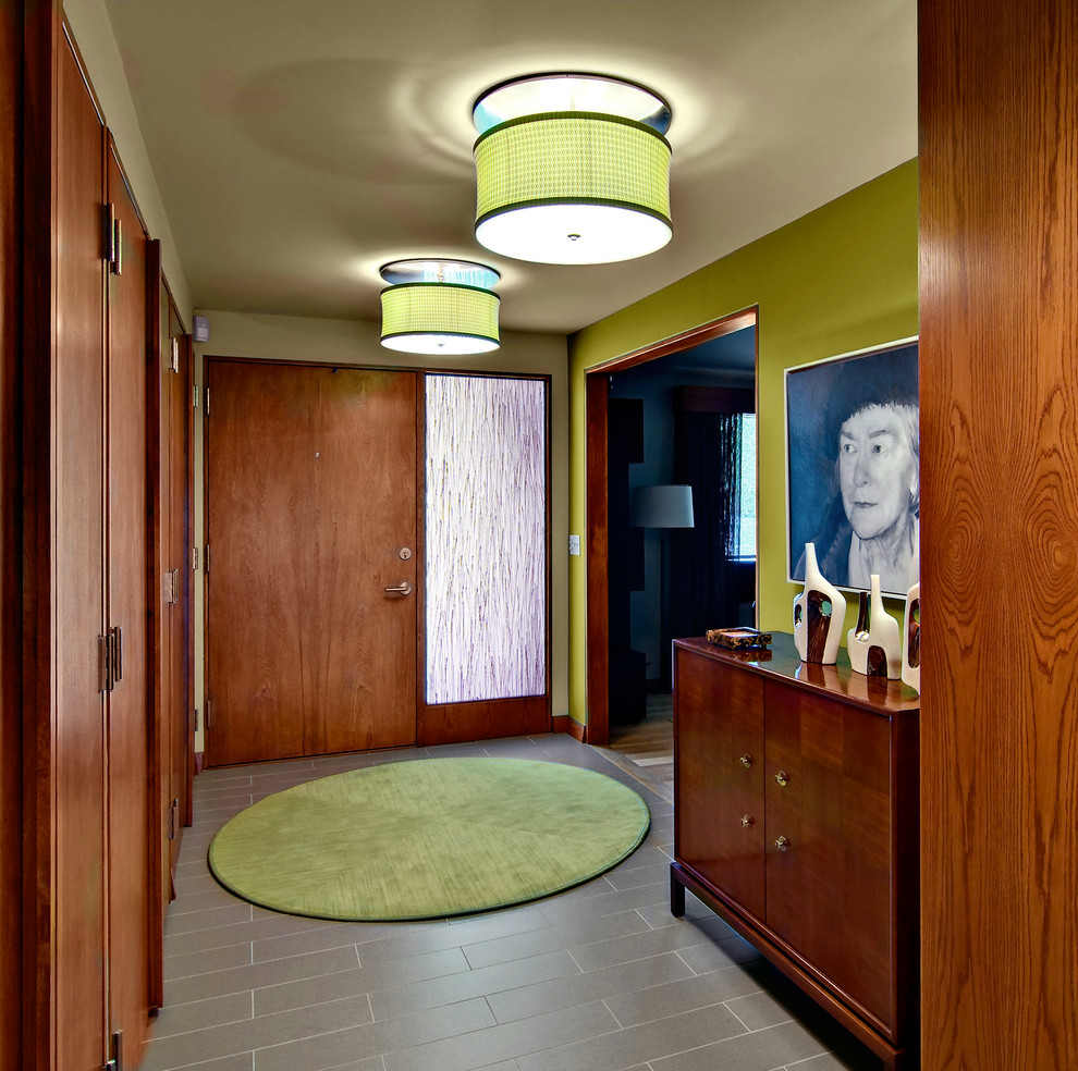 Inspiration for a midcentury foyer in Minneapolis with green walls, a single front door and a medium wood front door.