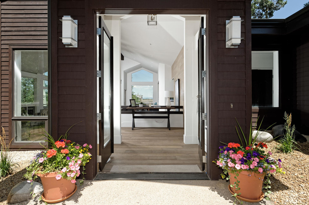 Inspiration pour un hall d'entrée traditionnel de taille moyenne avec un mur blanc, un sol en bois brun, une porte double, une porte en bois foncé et un sol marron.