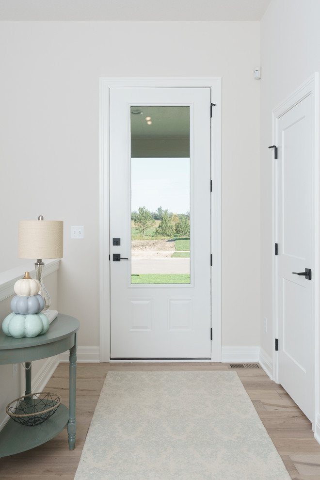 Medium sized traditional front door in Wichita with white walls, light hardwood flooring, a single front door, a white front door and brown floors.