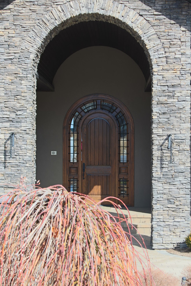 Ejemplo de puerta principal actual extra grande con puerta simple y puerta de madera en tonos medios