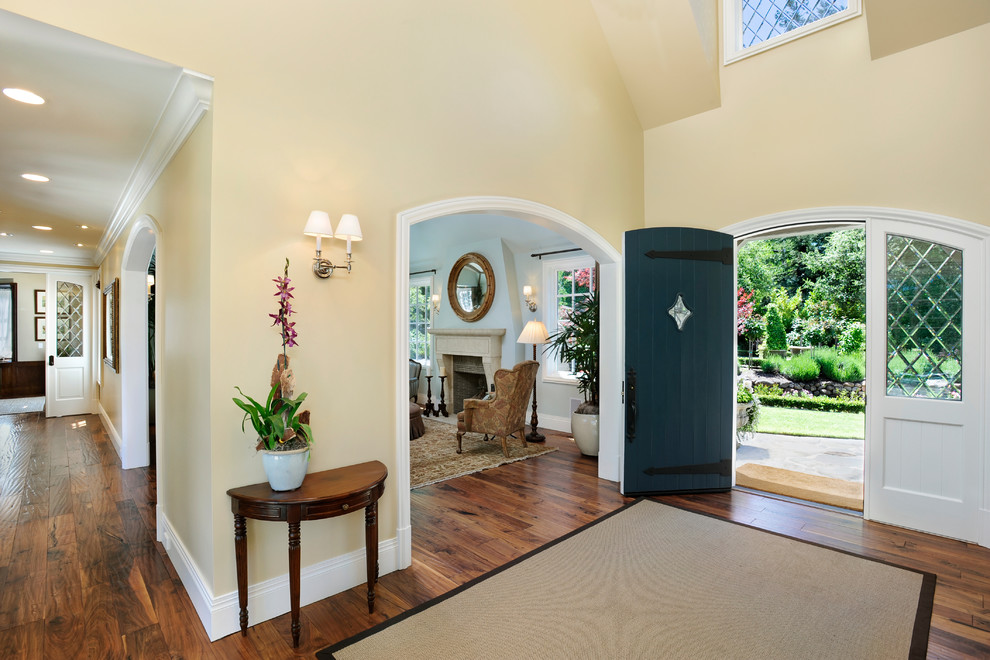Источник вдохновения для домашнего уюта: огромная входная дверь: освещение в классическом стиле с желтыми стенами, поворотной входной дверью и синей входной дверью