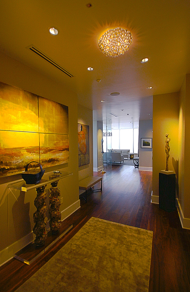 Immagine di un ingresso minimalista di medie dimensioni con pareti beige e pavimento in legno massello medio