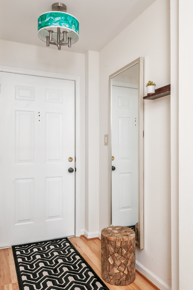 Foto på en liten funkis hall, med vita väggar, en vit dörr, ljust trägolv och en enkeldörr