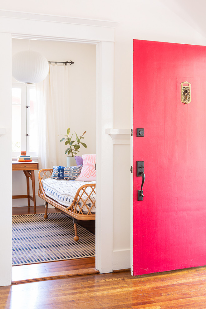 ロサンゼルスにあるトラディショナルスタイルのおしゃれな玄関 (白い壁、濃色無垢フローリング、赤いドア、茶色い床) の写真
