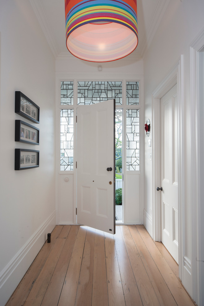 Foto de puerta principal tradicional renovada con paredes blancas, suelo de madera clara, puerta simple y puerta blanca