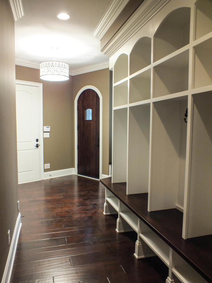 Inspiration for a huge timeless dark wood floor mudroom remodel in Cleveland with beige walls