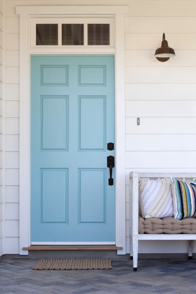 Lantlig inredning av en stor ingång och ytterdörr, med en enkeldörr och en blå dörr