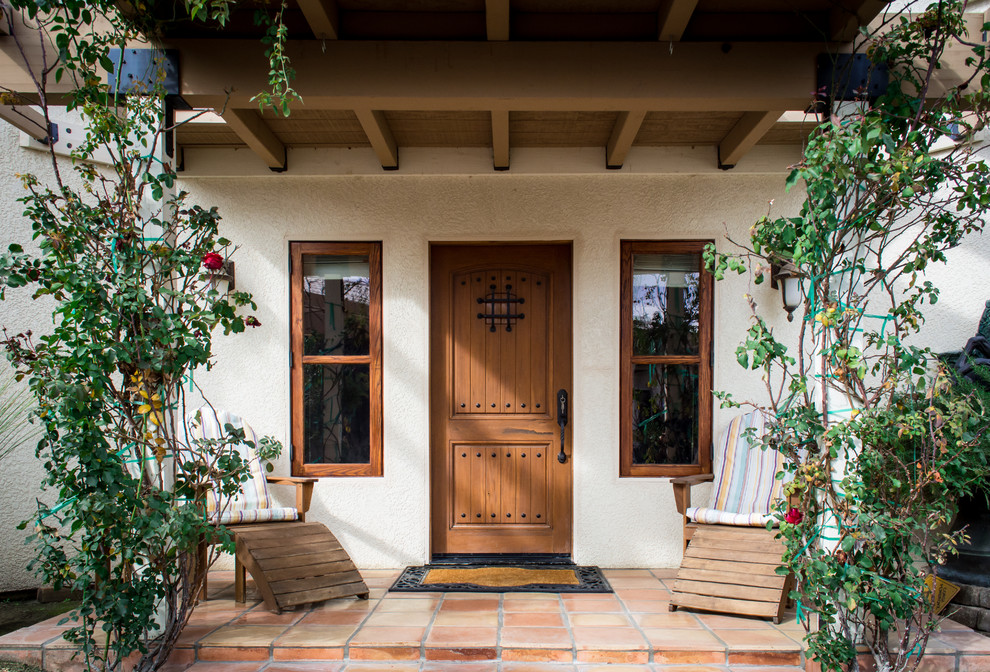 Идея дизайна: входная дверь в средиземноморском стиле с полом из терракотовой плитки, одностворчатой входной дверью и входной дверью из дерева среднего тона