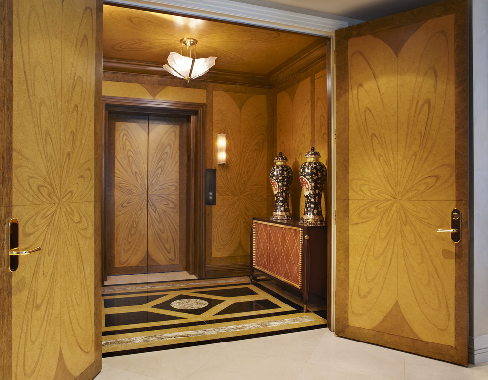 Cette image montre un grand vestibule design avec un sol en marbre, une porte double et une porte en bois brun.
