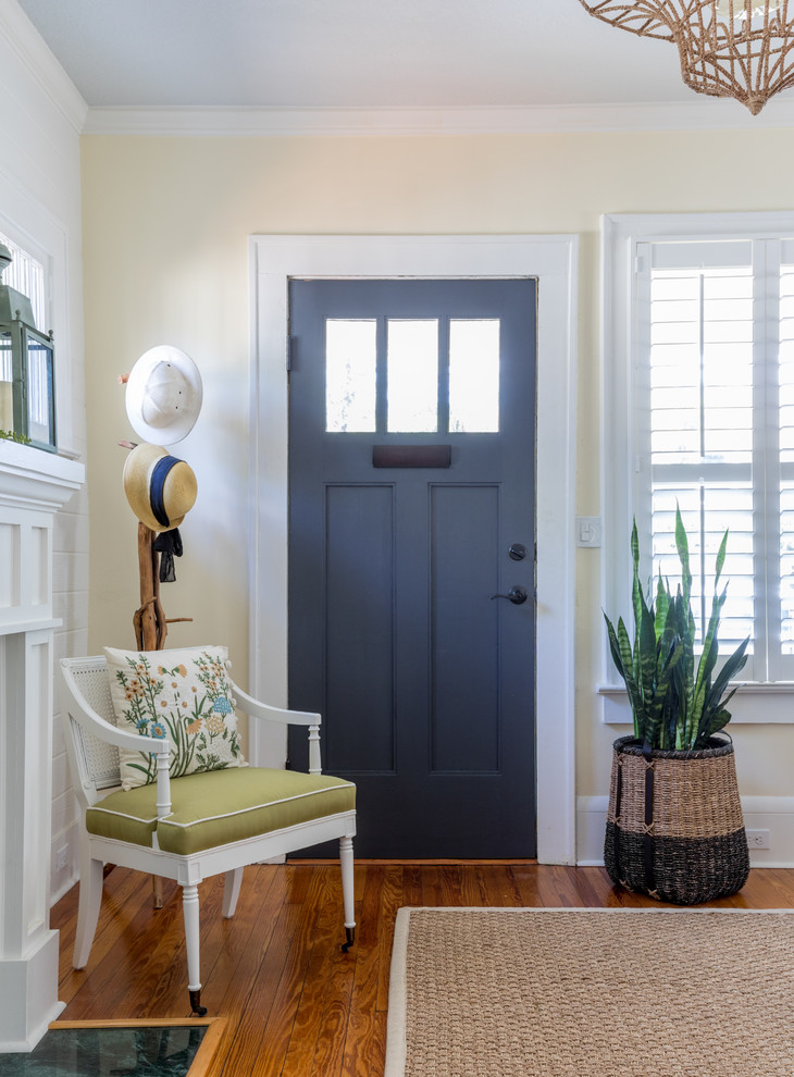 Cottage chic medium tone wood floor entryway photo in Jacksonville with yellow walls and a blue front door