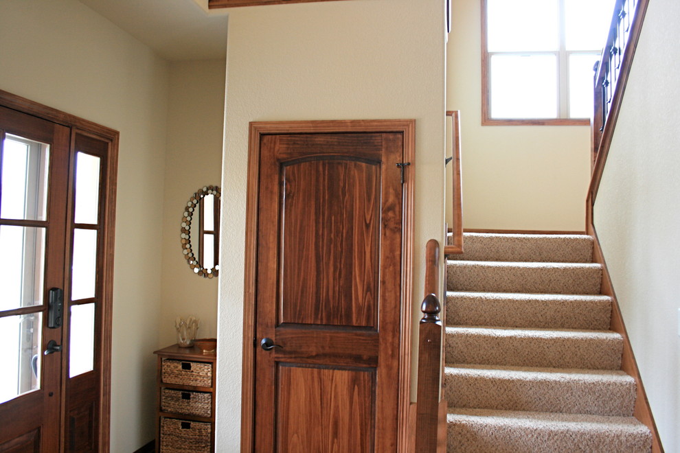 Réalisation d'une entrée tradition de taille moyenne avec un mur beige, parquet foncé, une porte simple et une porte en bois foncé.