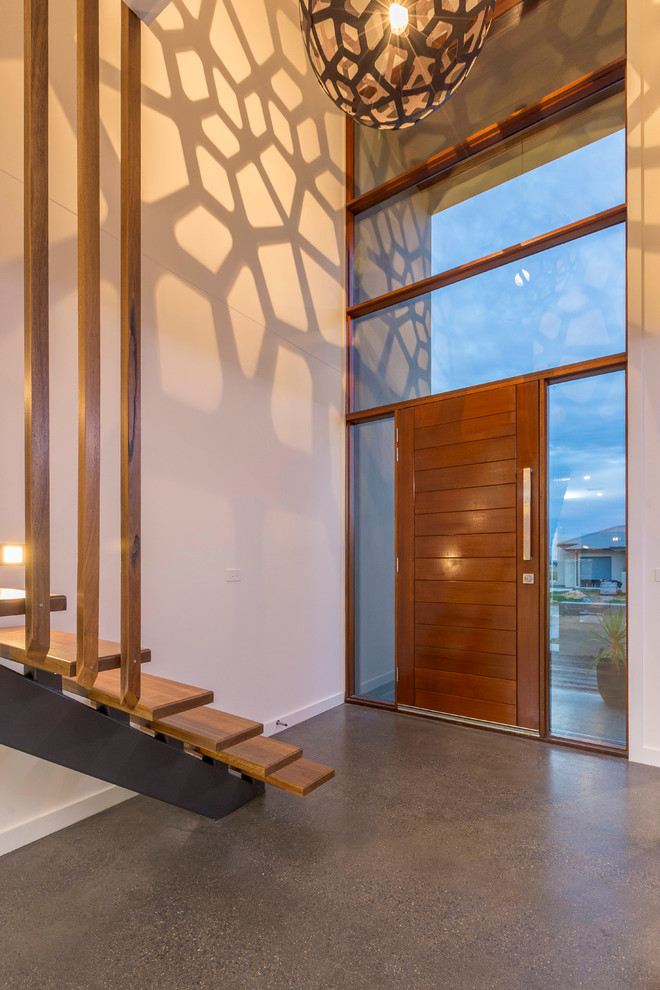 Front door - contemporary concrete floor front door idea in Canberra - Queanbeyan with white walls and a medium wood front door