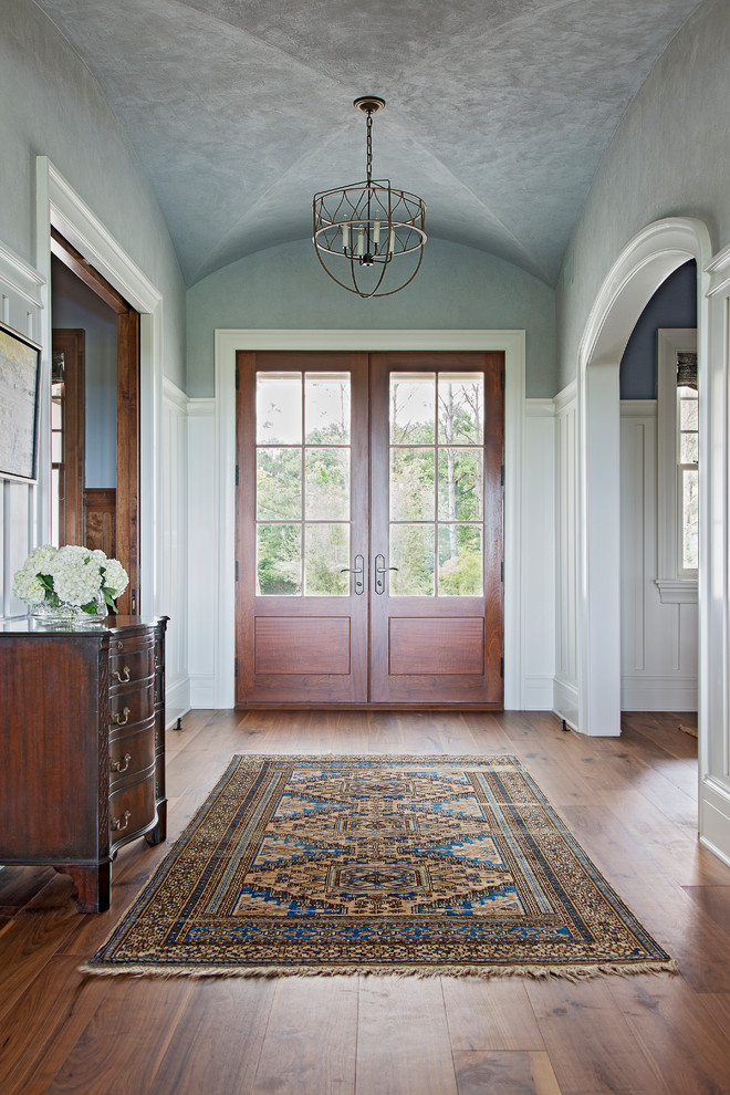 Foto di una grande porta d'ingresso tradizionale con pareti blu, pavimento in legno massello medio, una porta a due ante e una porta in legno bruno