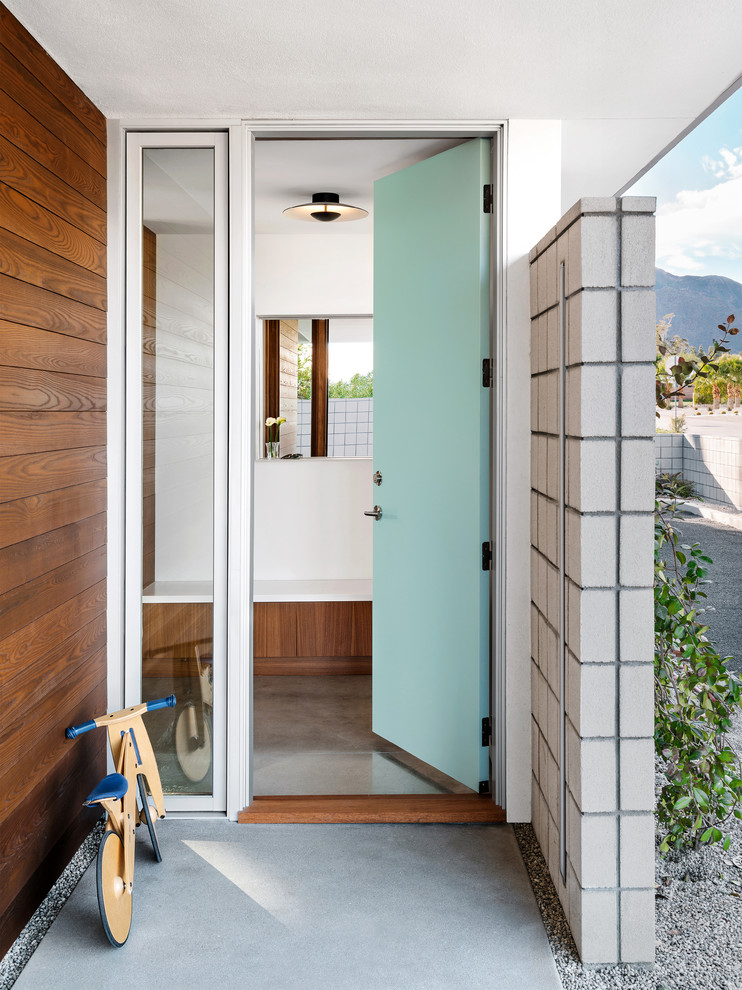 Идея дизайна: входная дверь среднего размера в современном стиле с белыми стенами, бетонным полом, одностворчатой входной дверью, синей входной дверью и серым полом