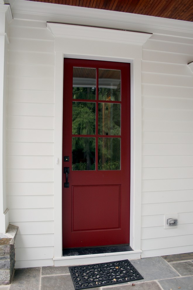 Idée de décoration pour une porte d'entrée tradition avec une porte simple et une porte rouge.
