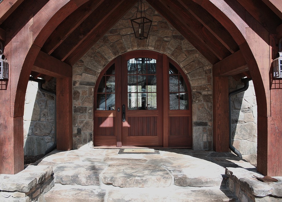 Aménagement d'une porte d'entrée montagne de taille moyenne avec une porte simple, une porte en bois foncé et un sol en ardoise.