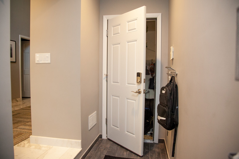 Источник вдохновения для домашнего уюта: узкая прихожая среднего размера в современном стиле с темным паркетным полом, одностворчатой входной дверью, белой входной дверью и коричневым полом