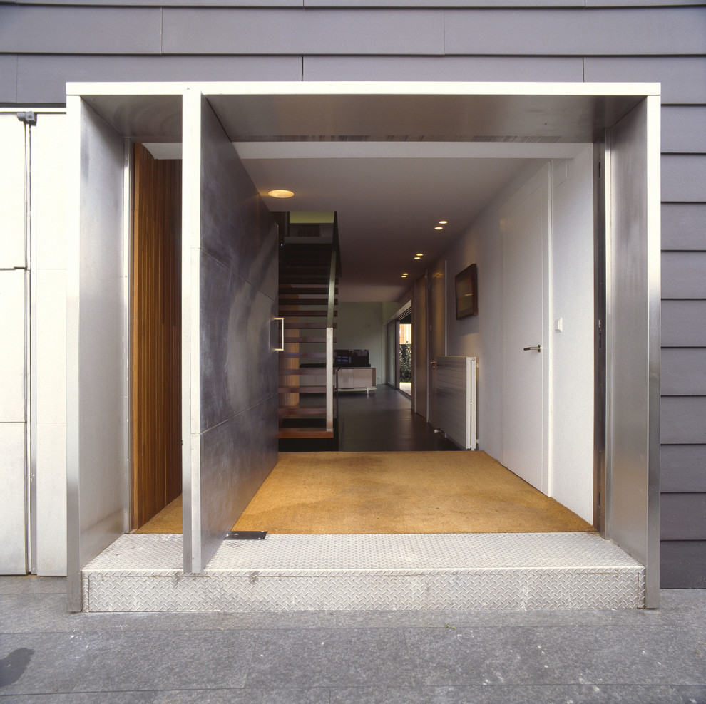 Стильный дизайн: входная дверь среднего размера в современном стиле с черными стенами, гранитным полом, поворотной входной дверью и металлической входной дверью - последний тренд