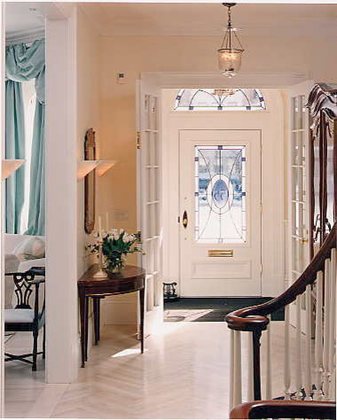 Diseño de distribuidor clásico de tamaño medio con paredes beige, suelo de madera clara, puerta simple y puerta blanca
