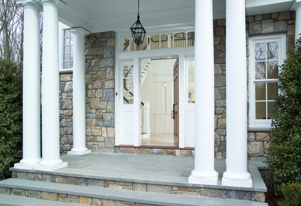Ispirazione per un'ampia porta d'ingresso tradizionale con pareti bianche, parquet chiaro, una porta singola e una porta marrone