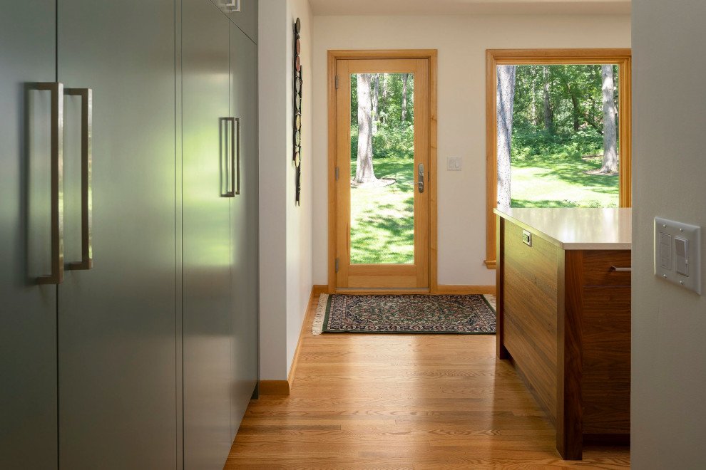 Ispirazione per un ingresso o corridoio moderno di medie dimensioni con parquet chiaro e una porta in legno chiaro