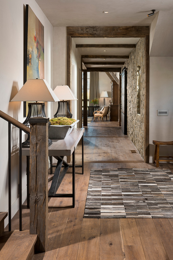 Inspiration for a rustic medium tone wood floor foyer remodel in Other with white walls