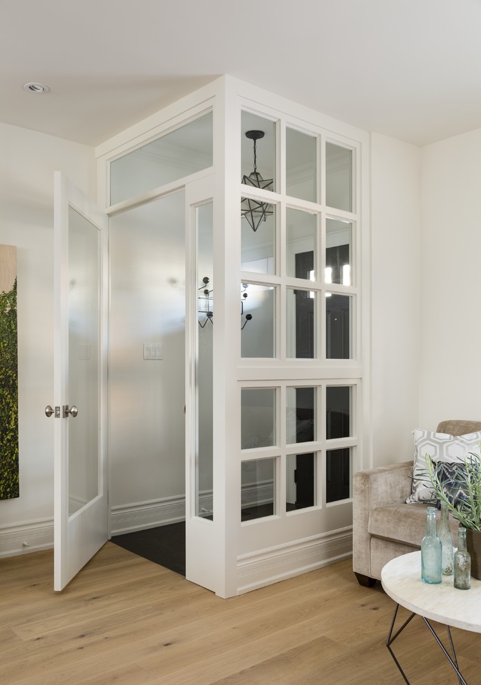 トロントにある高級な小さなトランジショナルスタイルのおしゃれな玄関ラウンジ (白い壁、御影石の床、濃色木目調のドア) の写真