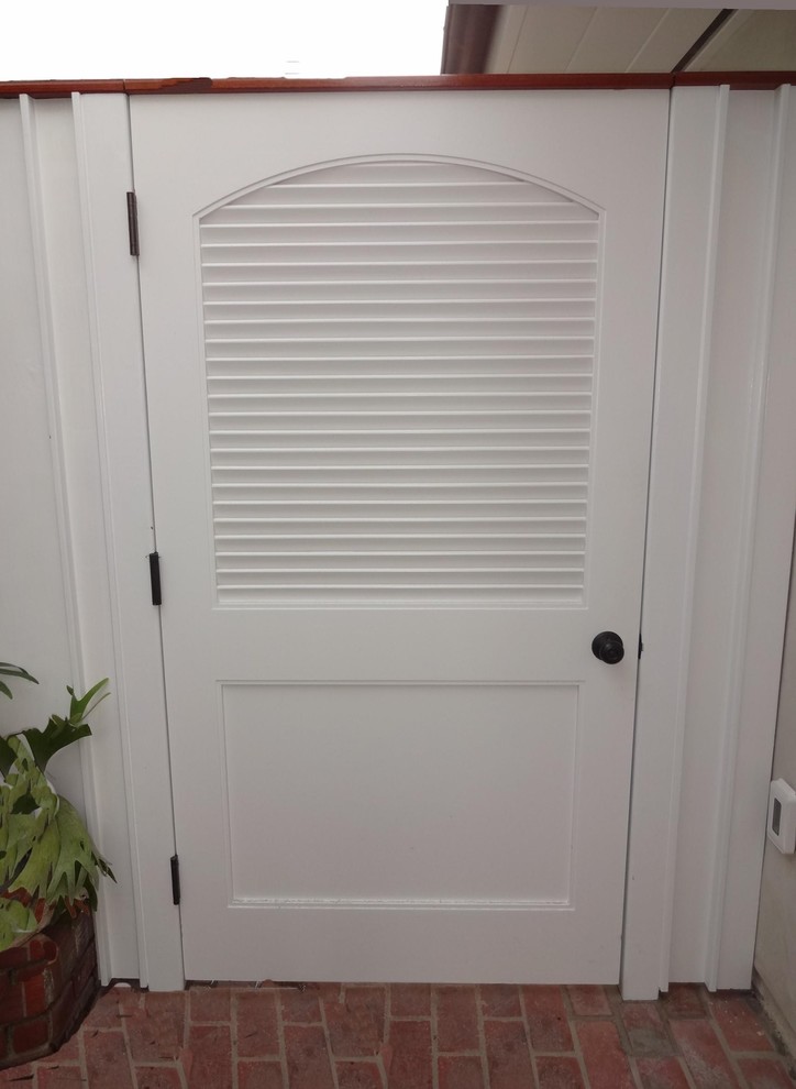 Foto de puerta principal costera de tamaño medio con suelo de ladrillo, puerta simple, puerta blanca, paredes blancas y suelo rojo
