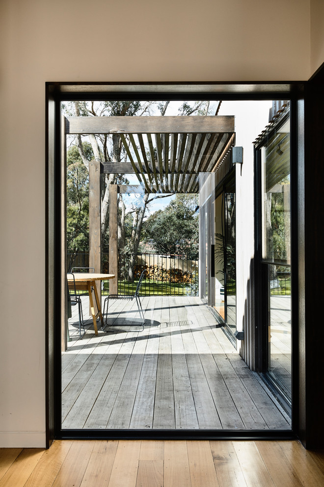 Réalisation d'un hall d'entrée design de taille moyenne avec un mur blanc, parquet clair, une porte simple et une porte en bois foncé.