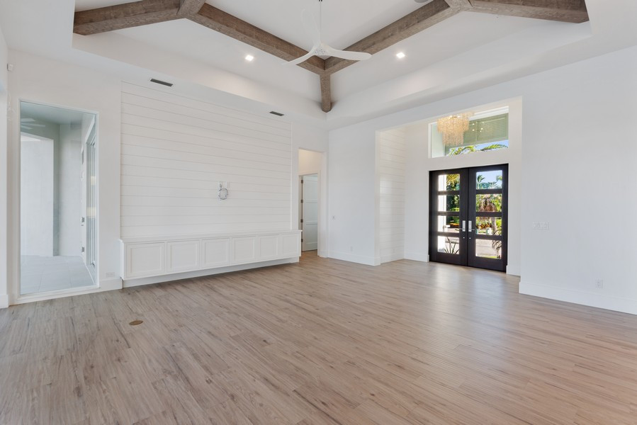 Inspiration for a large contemporary light wood floor and brown floor entryway remodel in Miami with white walls and a glass front door