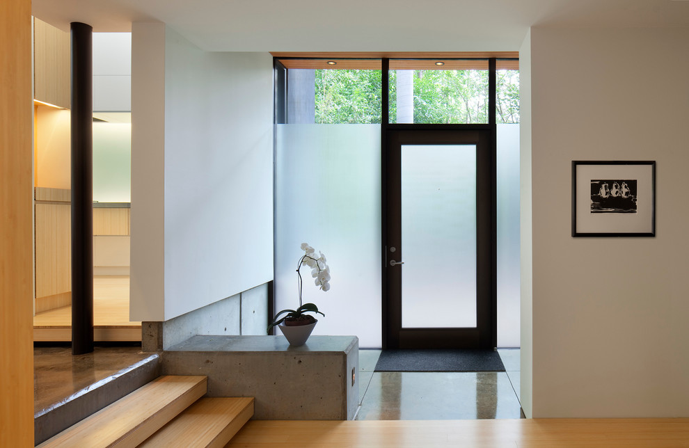 Immagine di un ingresso contemporaneo di medie dimensioni con pareti bianche, pavimento in bambù, una porta singola e una porta in vetro