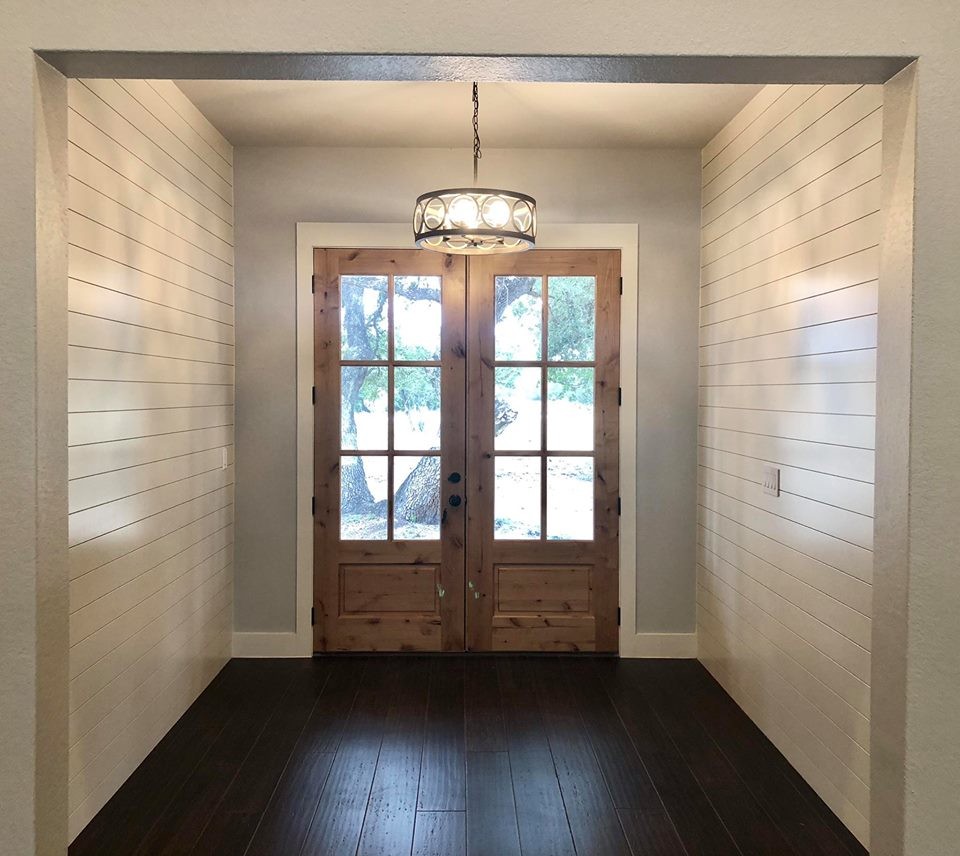 Mittelgroße Landhaus Haustür mit grauer Wandfarbe, dunklem Holzboden, Doppeltür und braunem Boden in Austin
