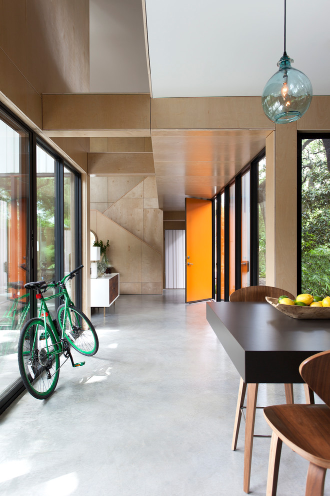 Foto de hall contemporáneo grande con suelo de cemento, puerta simple, puerta naranja, paredes beige y suelo gris