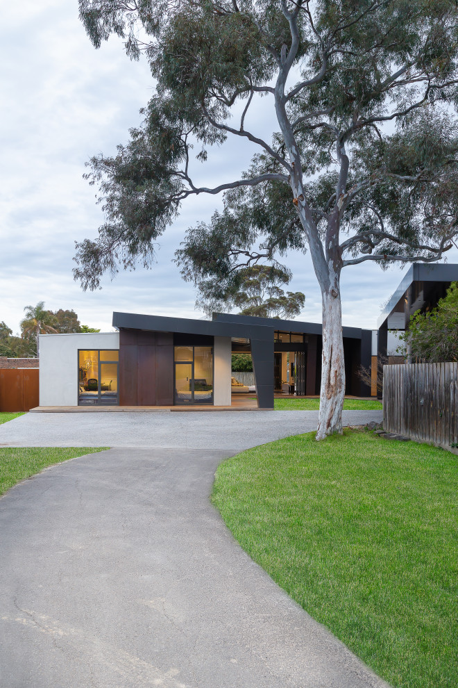 This is an example of a contemporary front door in Melbourne with black walls, concrete flooring and a light wood front door.
