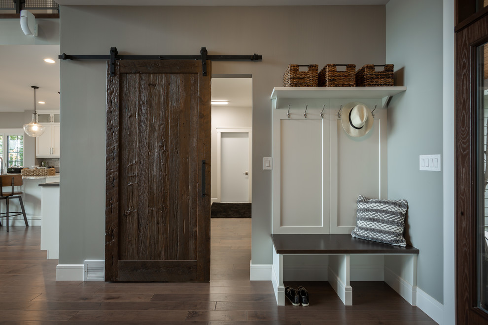 Großer Uriger Eingang mit Korridor, grauer Wandfarbe, dunklem Holzboden, Einzeltür, brauner Haustür und braunem Boden in Sonstige