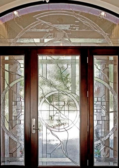 Esempio di un grande ingresso mediterraneo con pareti beige, pavimento in legno massello medio, una porta singola e una porta in vetro