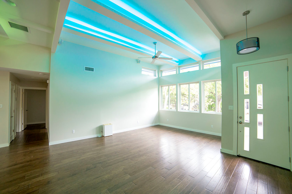This is an example of a medium sized contemporary foyer in Austin with a pivot front door and a white front door.