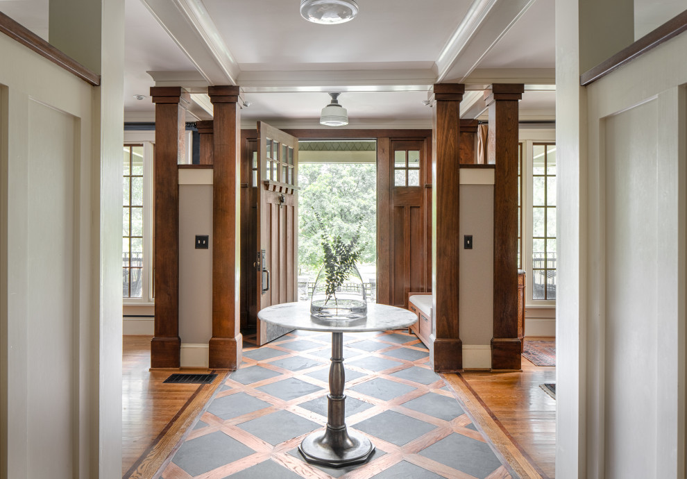 Пример оригинального дизайна: фойе в классическом стиле с серыми стенами, паркетным полом среднего тона, одностворчатой входной дверью, входной дверью из дерева среднего тона, коричневым полом и балками на потолке