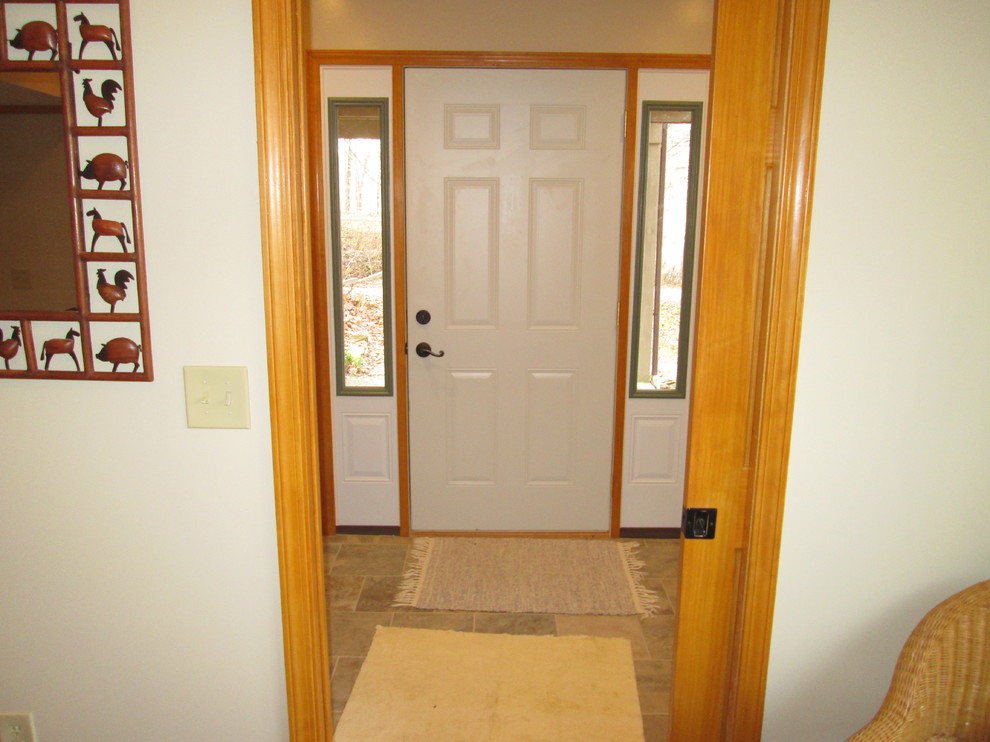 Mid-sized farmhouse ceramic tile entryway photo in Indianapolis with beige walls and a white front door
