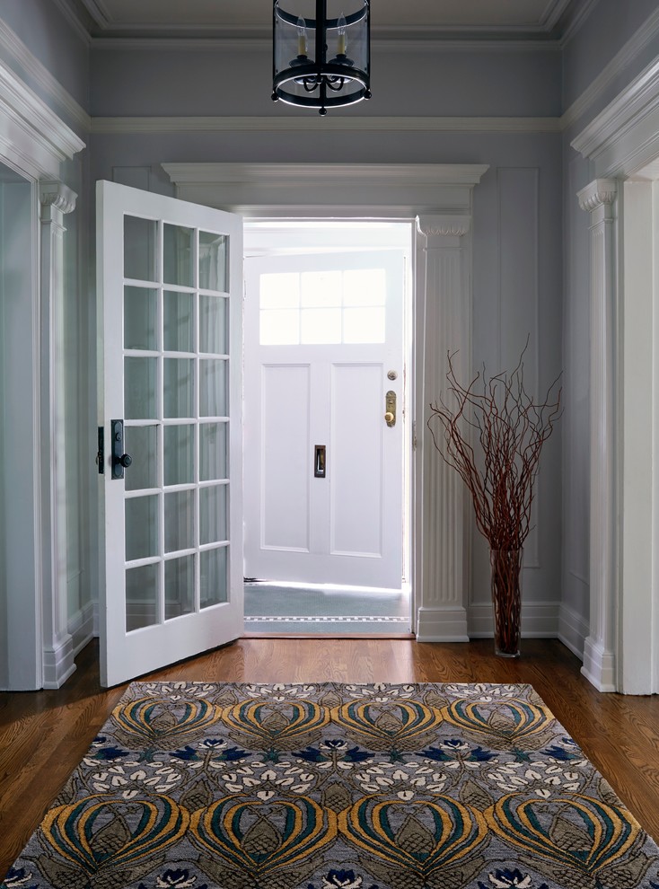 Imagen de distribuidor clásico de tamaño medio con paredes grises, puerta simple y puerta blanca