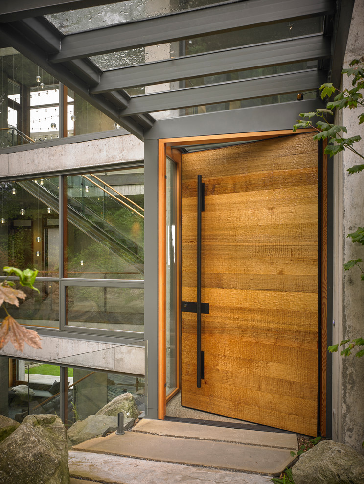 Réalisation d'une entrée design avec une porte simple et une porte en bois brun.