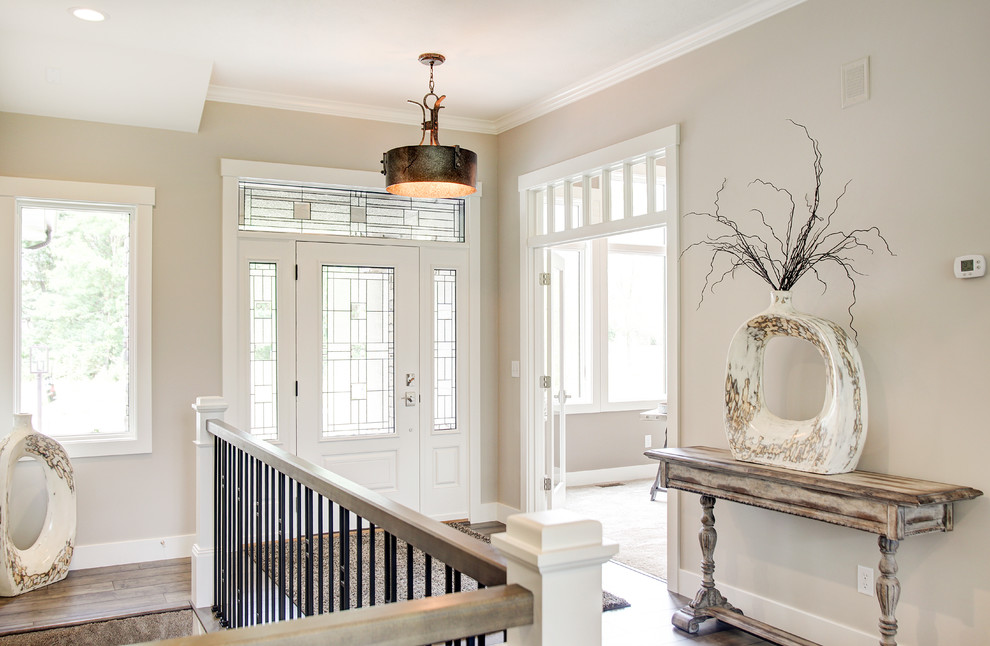 Mittelgroßes Klassisches Foyer mit beiger Wandfarbe, braunem Holzboden, Einzeltür und weißer Haustür in Sonstige