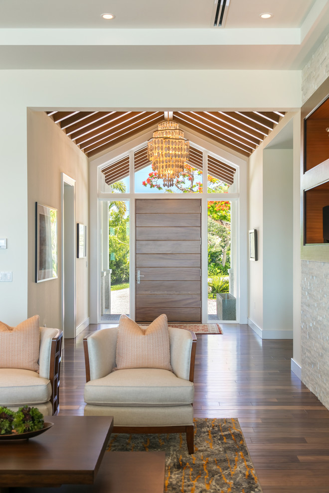 タンパにある高級な広いトランジショナルスタイルのおしゃれな玄関ロビー (白い壁、無垢フローリング、木目調のドア、茶色い床) の写真