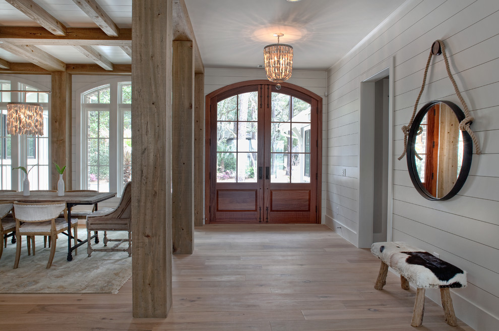 Großes Foyer mit weißer Wandfarbe, braunem Holzboden, Doppeltür und Haustür aus Glas in Charleston
