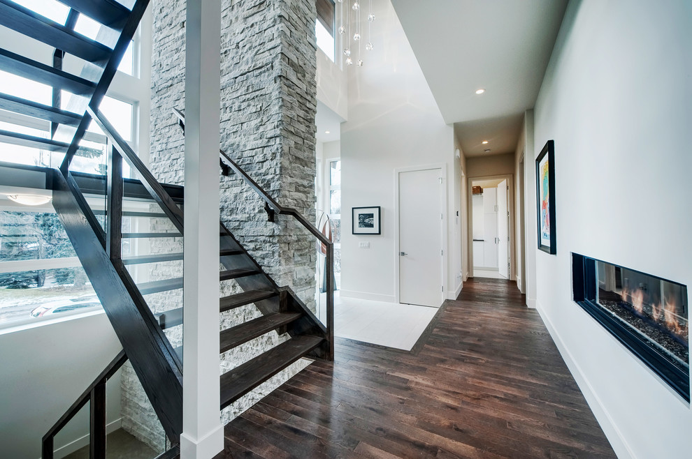 Photo of a large modern foyer in Calgary with white walls, medium hardwood flooring, a single front door and a medium wood front door.