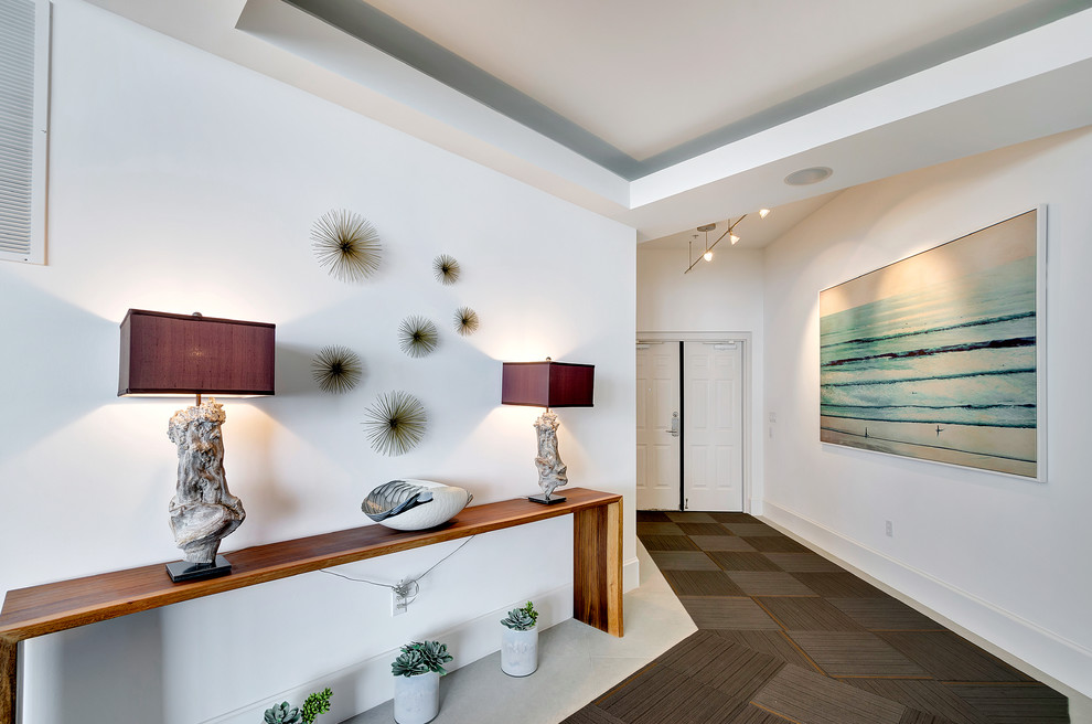 This is an example of a contemporary entrance in Miami with concrete flooring and feature lighting.